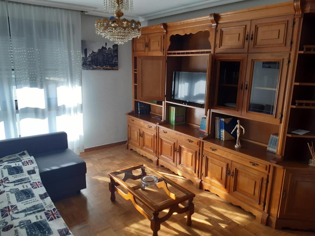 una sala de estar con un gran centro de entretenimiento de madera en Apartamento Brañavalera, en Pola de Lena
