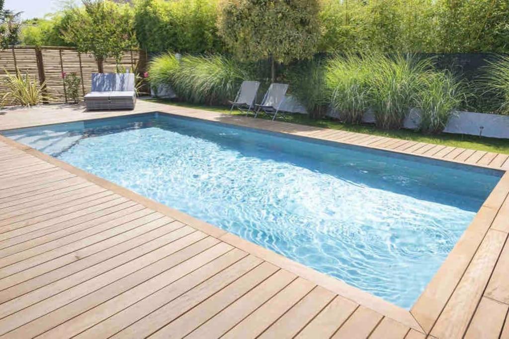 una gran piscina con terraza de madera en Isola Bianca, en Isola delle Femmine