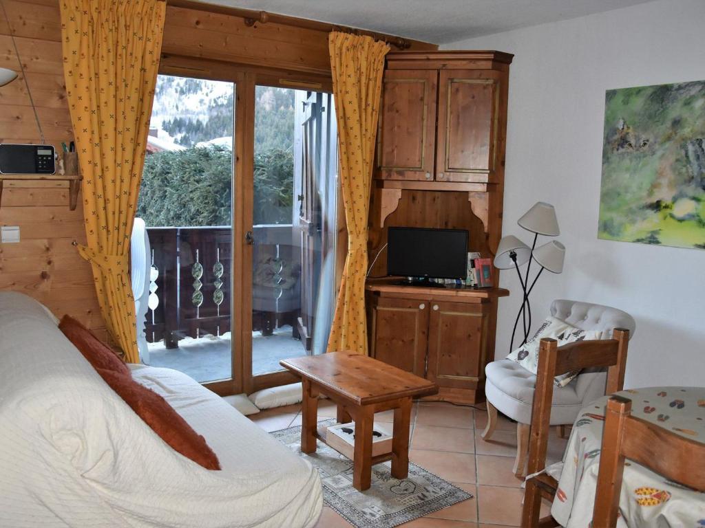 une chambre avec un lit et un bureau avec une télévision dans l'établissement Charmant 3 pièces en rez-de-jardin, proche pistes, idéal familles - FR-1-464-57, à Pralognan-la-Vanoise