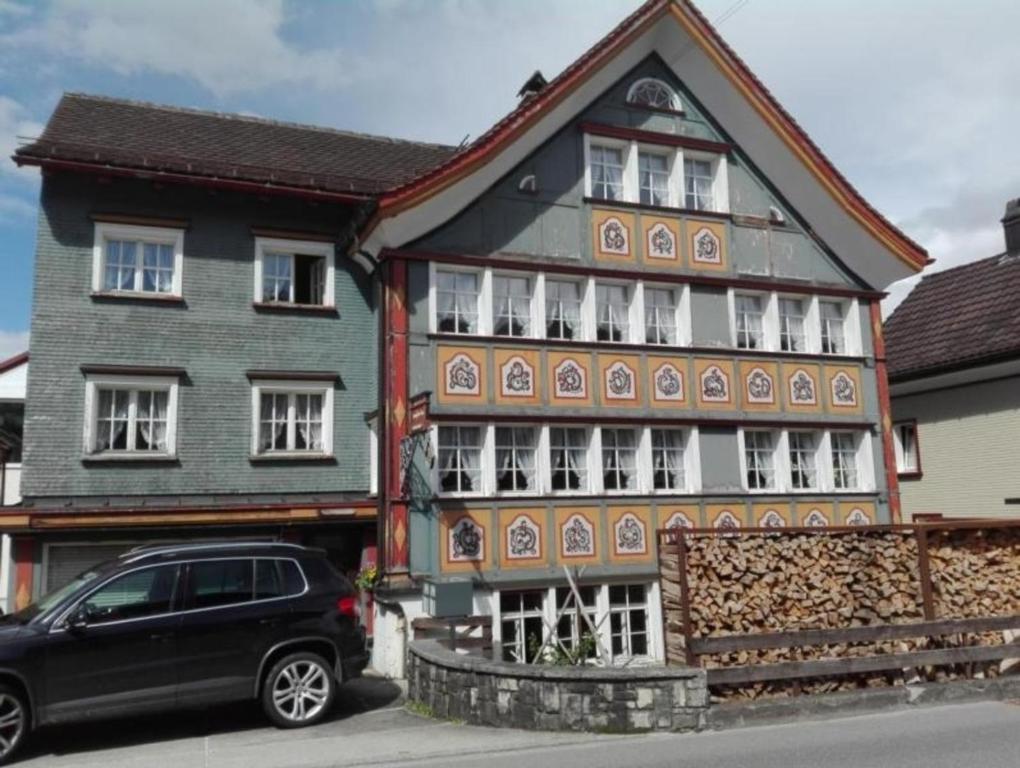 a black car parked in front of a house at Ferienwohnung Blaues Haus in Appenzell