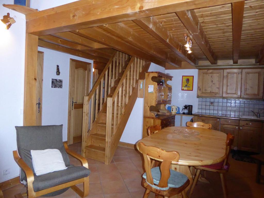 une cuisine avec une table en bois et un escalier en bois dans l'établissement Duplex familial 7 pers, proche pistes, balcon, quartier résidentiel - FR-1-464-61, à Pralognan-la-Vanoise