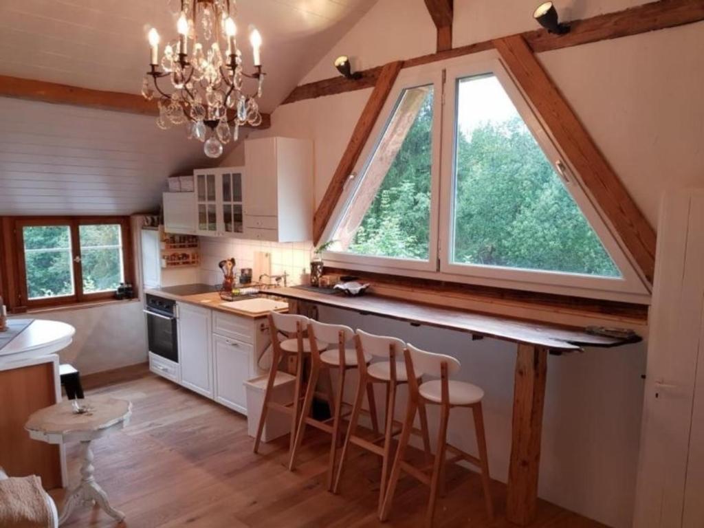a kitchen with a large window and a counter with stools at Studio Chic mit Whirlpool in Wildhaus