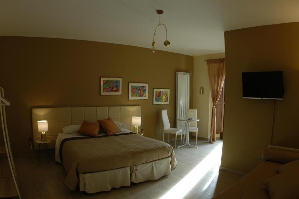 a bedroom with a bed and a flat screen tv at Dimora Offidius in LʼAquila