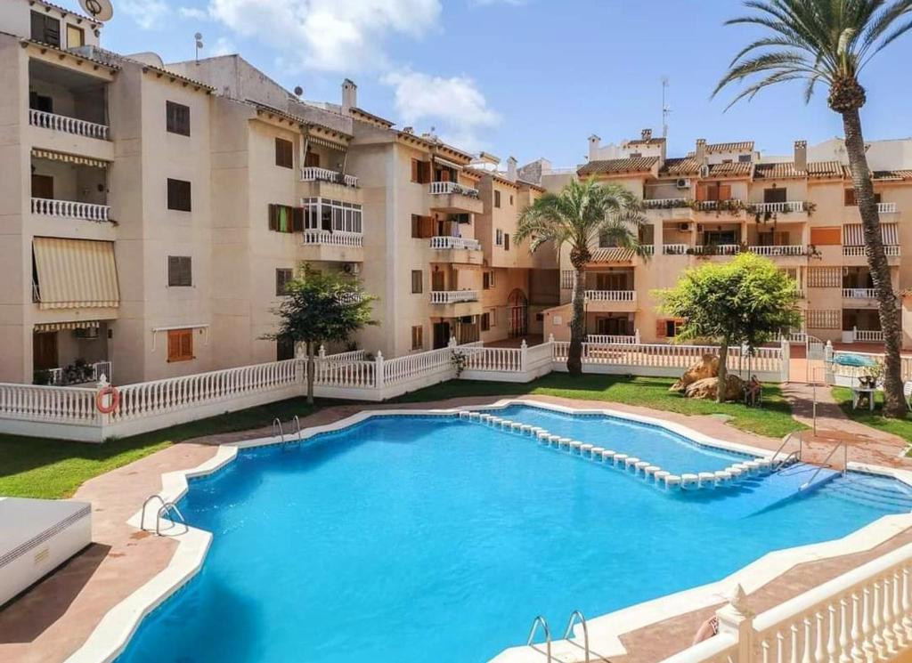 una grande piscina di fronte agli edifici degli appartamenti di Casa Del Angel , Cosy 2 bed apartment,150m from Playa Los Locos plus beautiful swimming pool a Torrevieja