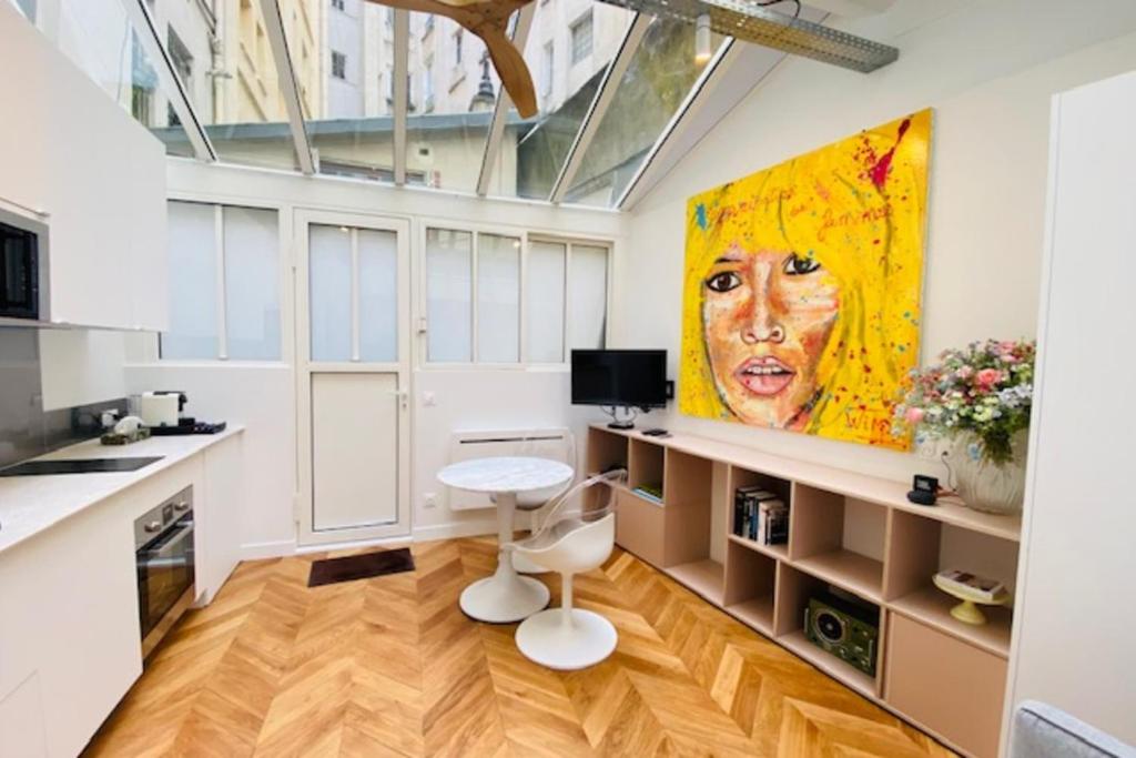 a kitchen with a painting of a woman on the wall at Warm 18m ideal for couple in Paris in Paris