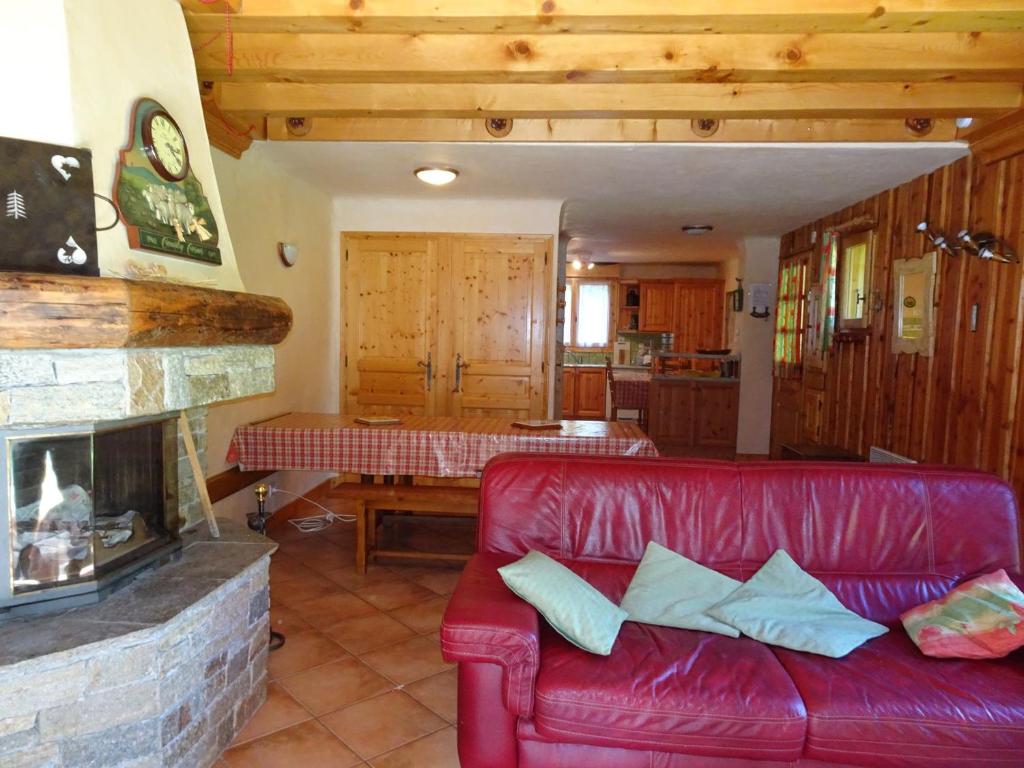 - un canapé rouge dans le salon avec cheminée dans l'établissement Spacieux Triplex pour 12 pers, Terrasse, Cheminée, Garage - FR-1-464-19, à Champagny-en-Vanoise
