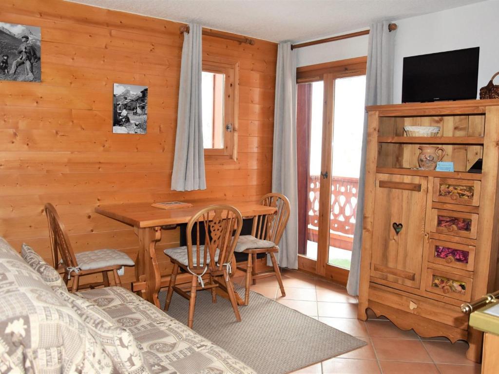 une chambre avec une table, des chaises et un lit dans l'établissement Charmant appartement proche des pistes, balcon, animaux admis - FR-1-464-6, à Pralognan-la-Vanoise