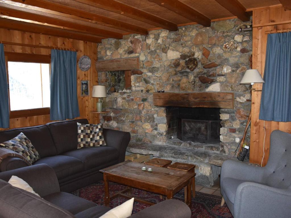 a living room with couches and a stone fireplace at Chalet Pralognan-la-Vanoise, 7 pièces, 12 personnes - FR-1-464-11 in Pralognan-la-Vanoise