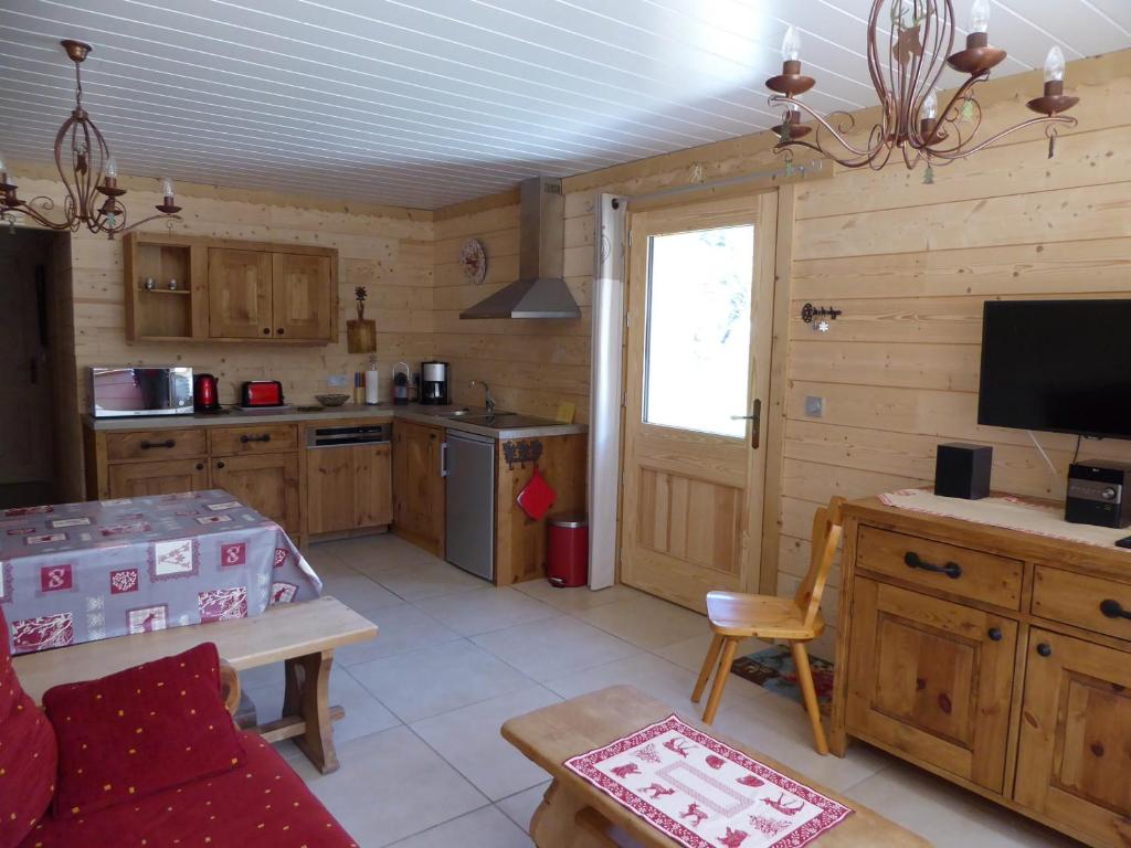 プラローニャン・ラ・ヴァノワーズにあるAppartement Pralognan-la-Vanoise, 3 pièces, 4 personnes - FR-1-464-29のキッチン(木製キャビネット、テーブル、テレビ付)