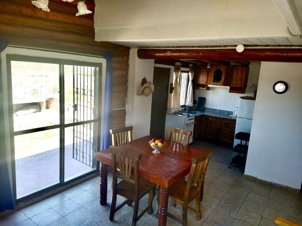 盧漢德庫約的住宿－Cabaña Mimi，厨房配有木桌、椅子和窗户。