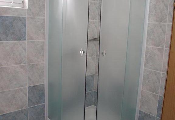 La salle de bains est pourvue d'une douche avec une porte en verre. dans l'établissement Hvar beach vacation, à Vrboska