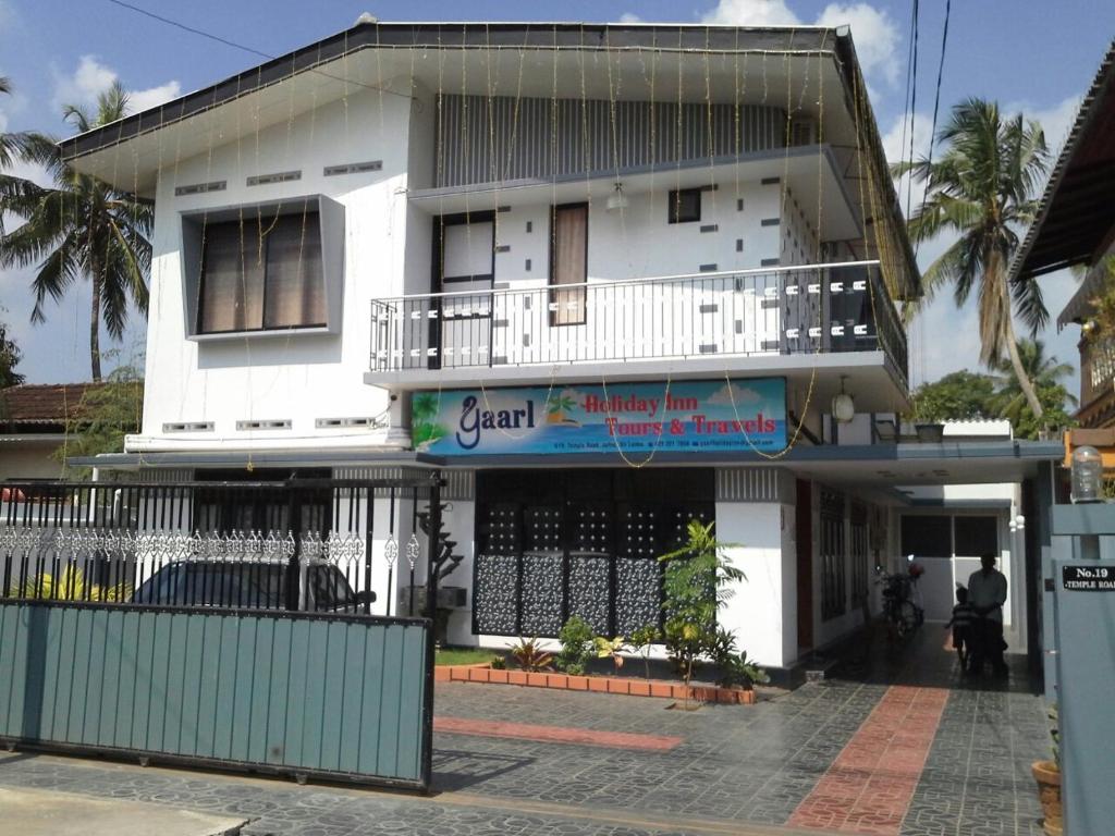 een wit gebouw met een balkon erboven bij Yaarl Holiday in Jaffna