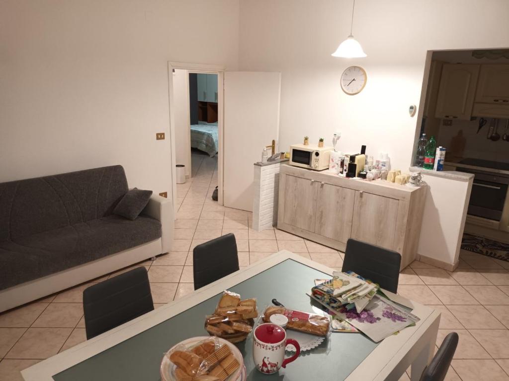un soggiorno con tavolo e divano di L'appartamento delle vacanze a Venturina Terme