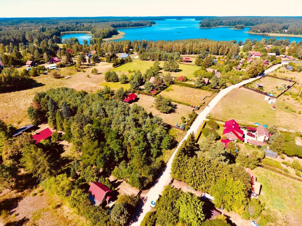 an aerial view of a farm with a lake at Pod lipą in Ruciane-Nida