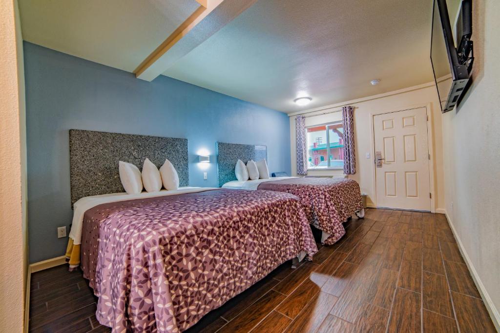 a hotel room with two beds and a window at Turlock Inn in Turlock