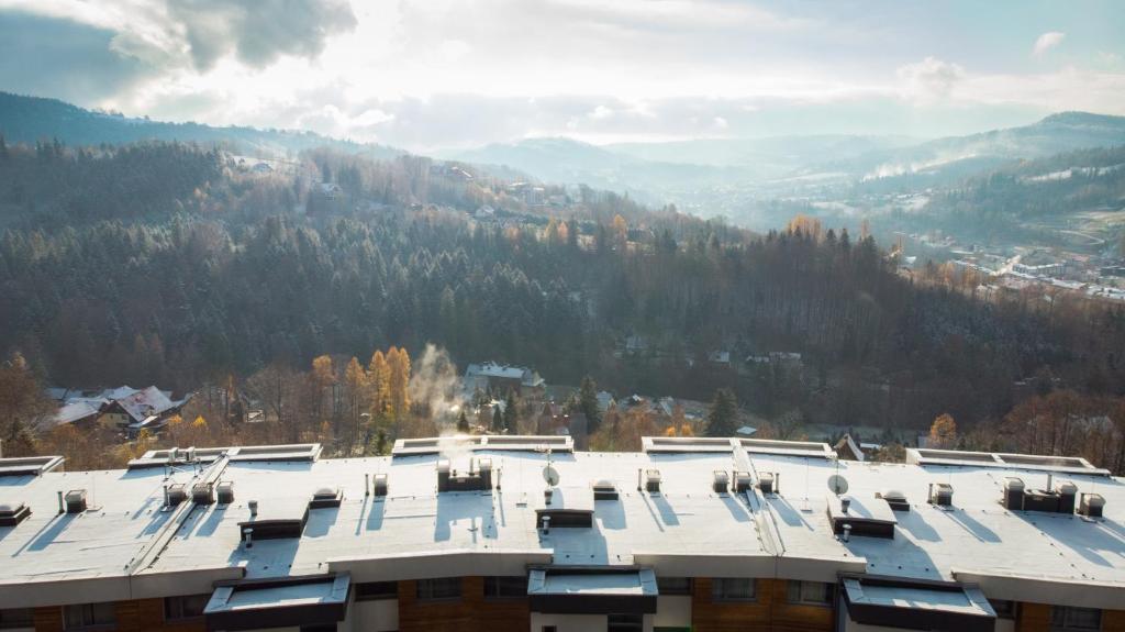 a building with a snowy roof in the mountains at ApartView Premium by Rent like home in Wisła
