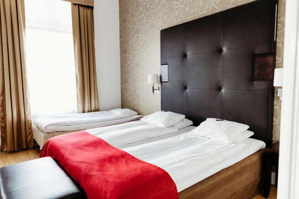 Postel nebo postele na pokoji v ubytování Vimmerby Stadshotell, WorldHotels Crafted