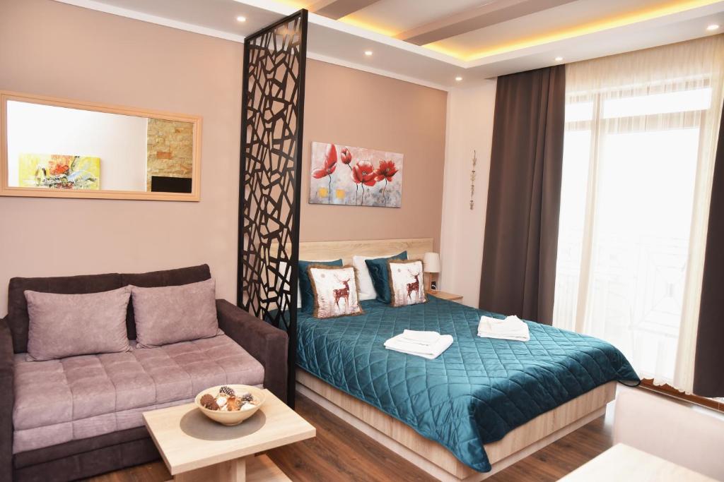 a bedroom with a bed and a couch at Apartman Pleasure M4 Milmari Resort in Kopaonik