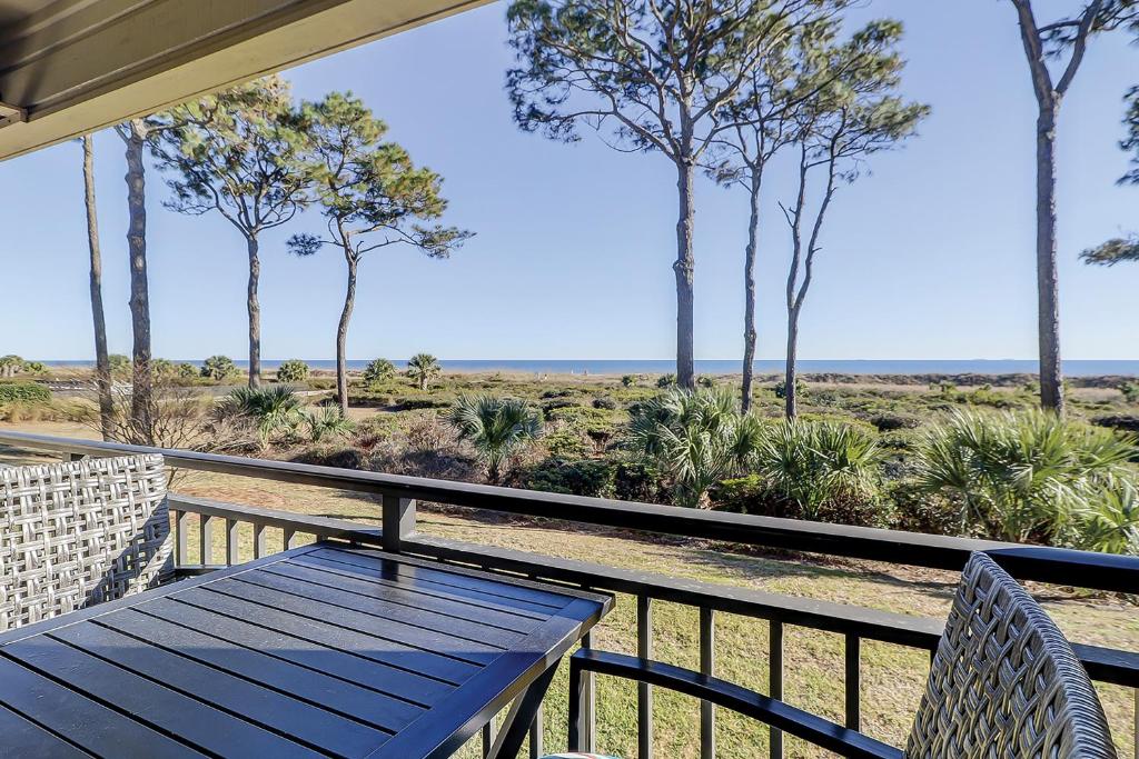 a porch with a table and chairs and trees at Sea Side Villas 171 in Hilton Head Island