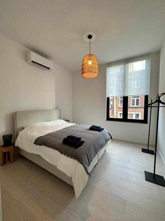 a bedroom with a bed and a large window at Appartement lumineux hyper centre in Liège