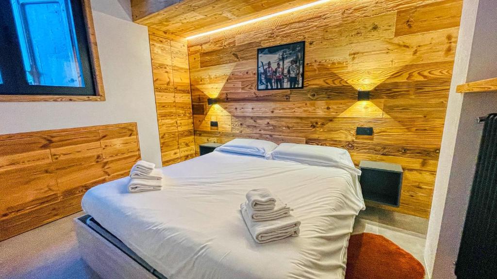 a bedroom with a bed in a wooden wall at Appartamento Livia - Affitti Brevi Italia in Bardonecchia