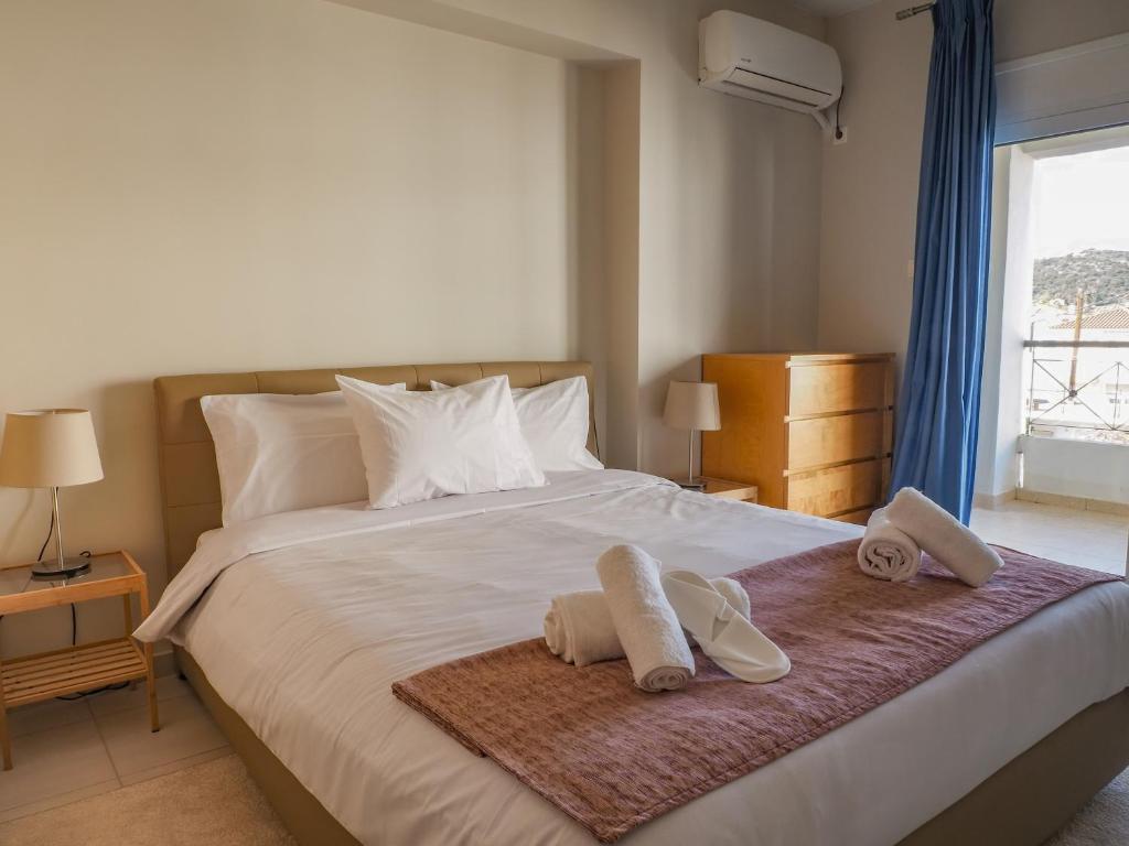 um quarto com uma cama com toalhas e sapatos em Sea end Sun em Volos