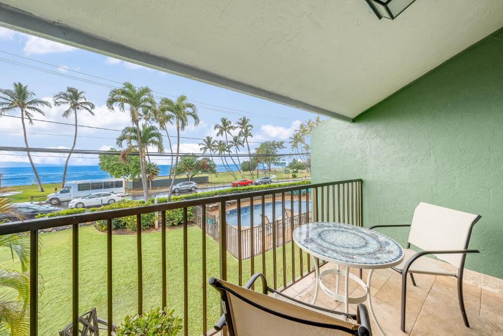 a balcony with a table and chairs and the ocean at Kihei Park Shores 13 in Kihei