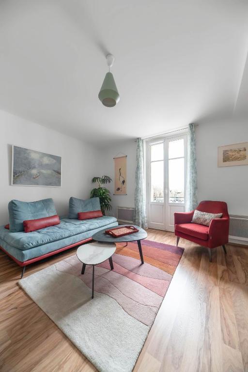 a living room with a couch and a table at Appartement design La Petite Europe - Idéal Curistes in Vichy