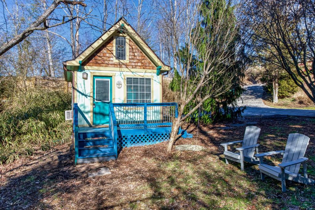 a small house with two chairs in front of it at Tiny Blue Ridge Gem in Arden