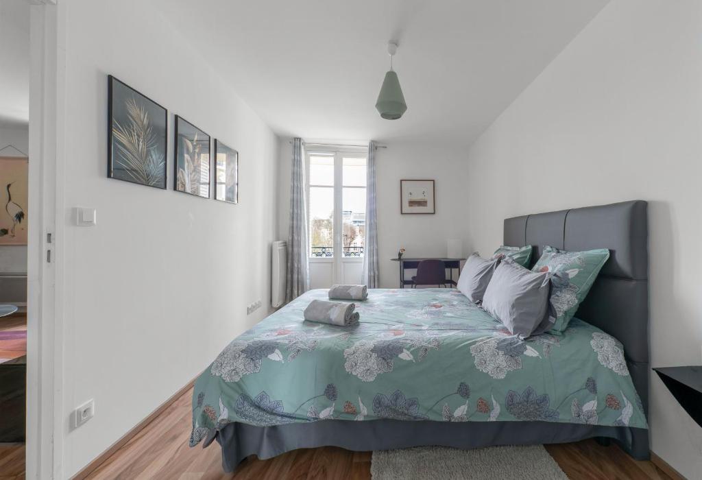 um quarto com uma cama com um edredão azul em Appartement design La Petite Europe - Idéal Curistes em Vichy