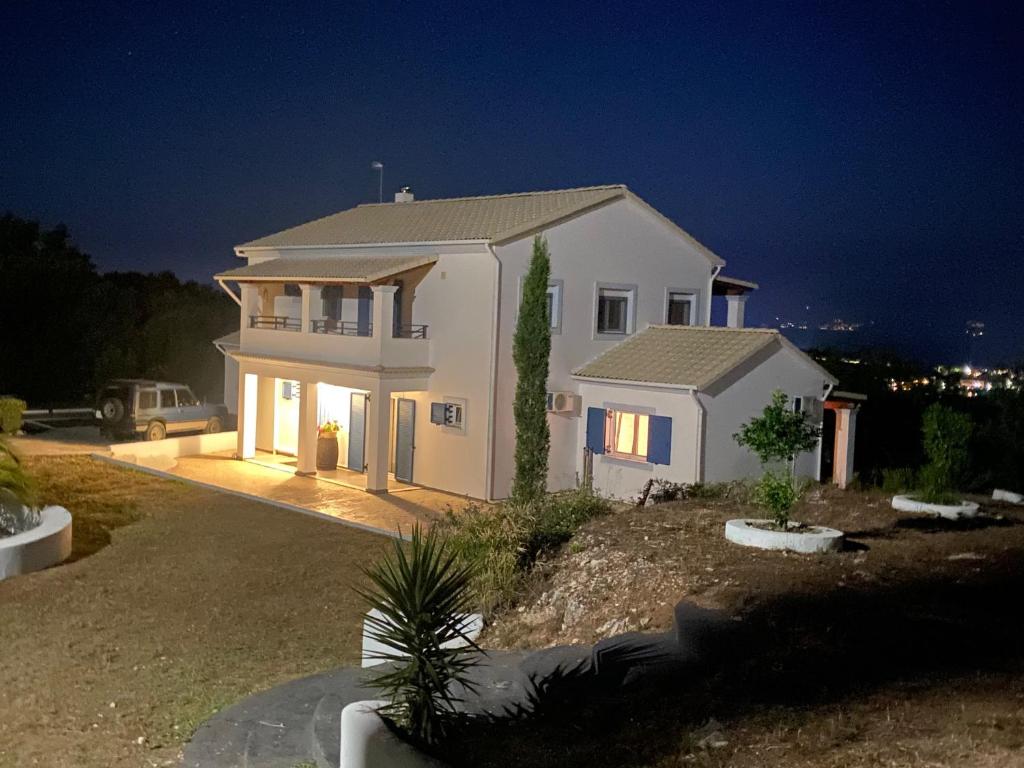 una grande casa bianca di notte con le luci accese di House of the Barrel Maker a Sfakerá