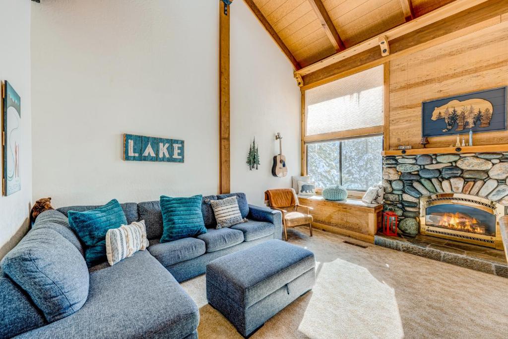 uma sala de estar com um sofá azul e uma lareira de pedra em The Pines at Rocky Point em Truckee