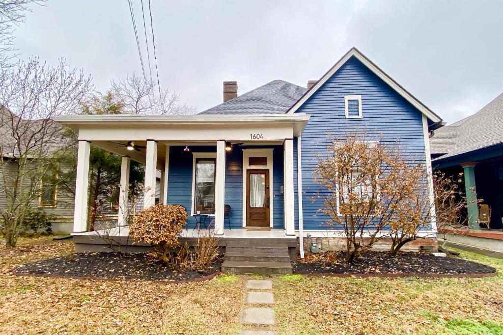 une maison bleue avec une porte d'entrée et une terrasse couverte dans l'établissement Woodland Wonder, à Nashville