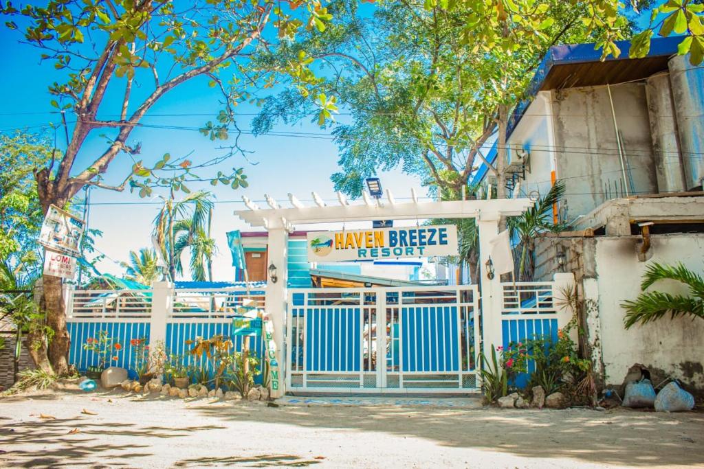een gebouw met een blauwe poort en een bord bij HAVEN BREEZE RESORT - A home of Hundred Islands in Alaminos