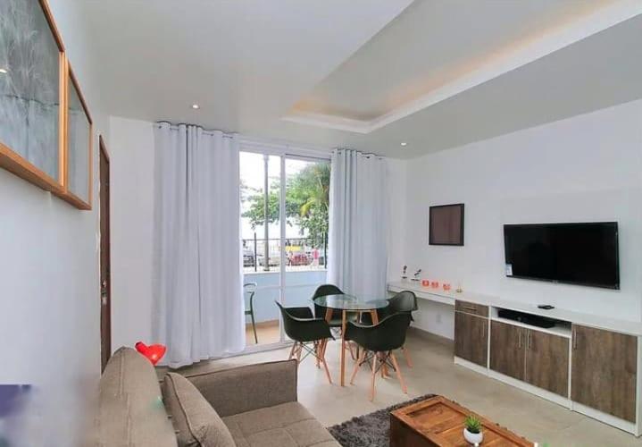 sala de estar con sofá, mesa y TV en Rio Flat Copacabana Beach, en Río de Janeiro