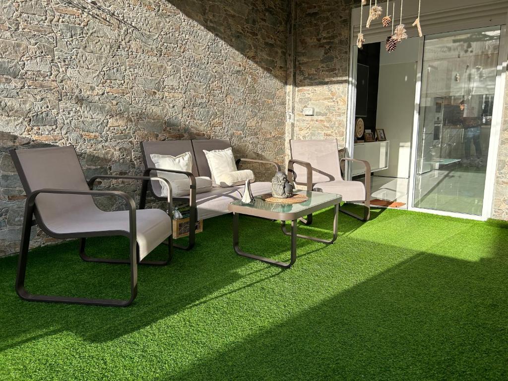 een woonkamer met stoelen en een tafel en groen tapijt bij ENZO SUITE in Las Palmas de Gran Canaria