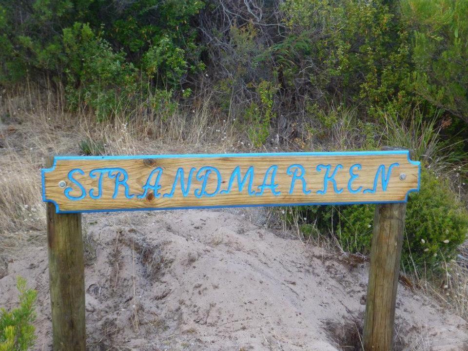 a wooden sign on the side of a beach at Strandmarken in Island Beach