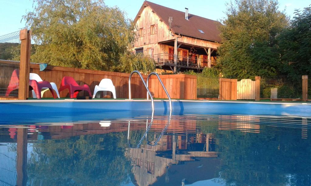 a swimming pool with chairs next to a house at Moulin D’Huile in Chaumard
