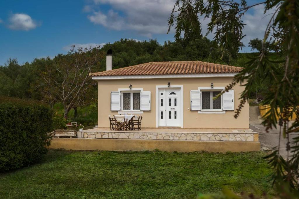 una pequeña casa amarilla con mesa y sillas en Arba private House en Áyios Dhimítrios