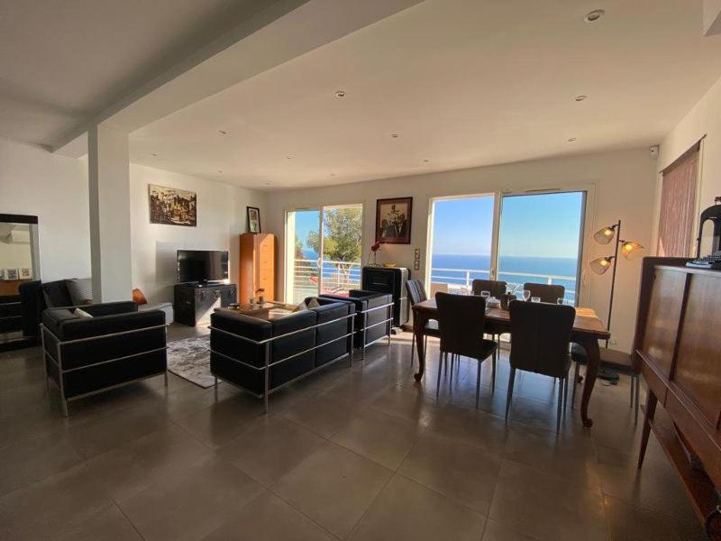 a large living room with a table and chairs at Vue mer.Tranquilité.Cap d&#39;Ail à 10 mn de MONACO in Cap d&#39;Ail