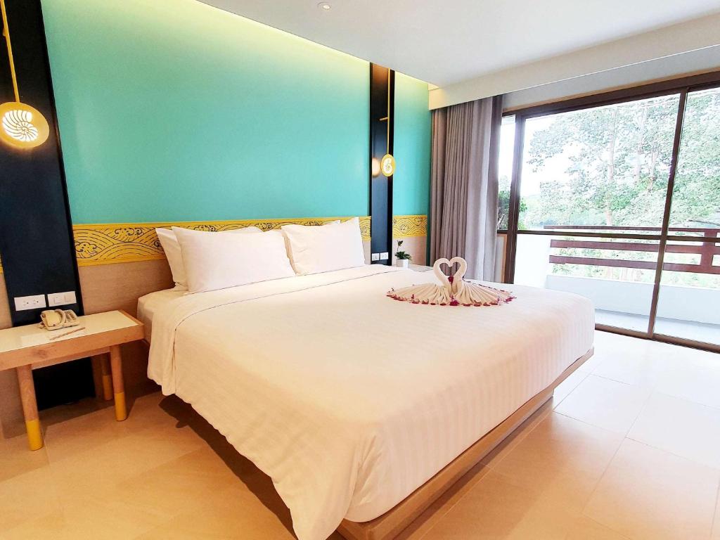 a bedroom with a large bed and a large window at Novotel Rayong Rim Pae Resort in Klaeng