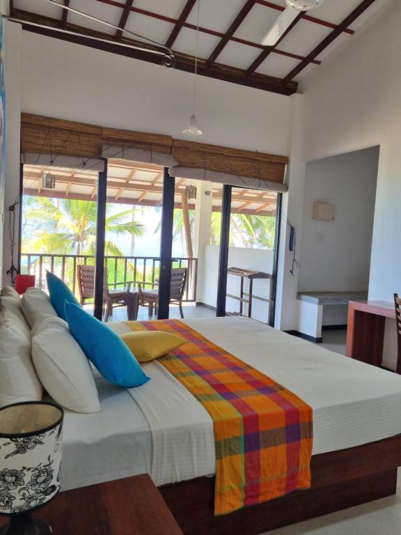 a bedroom with a large bed with blue pillows at Wellé Wadiya Beach Villa in Kalpitiya