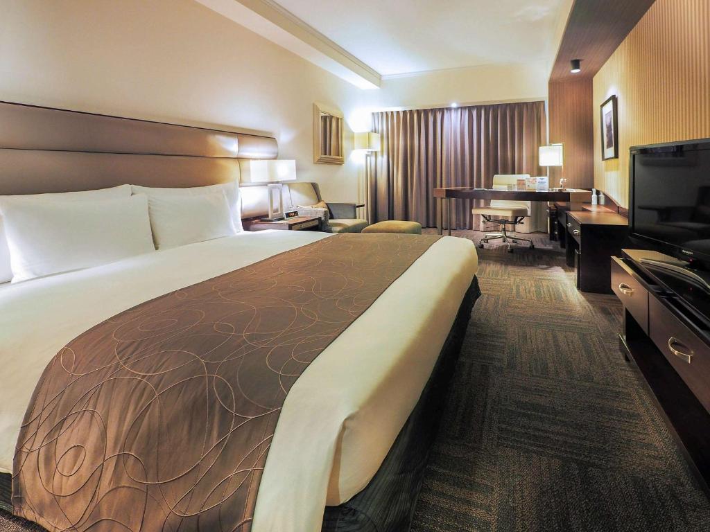 札幌市にあるイビス スタイルズ 札幌の大きなベッドとデスクが備わるホテルルームです。