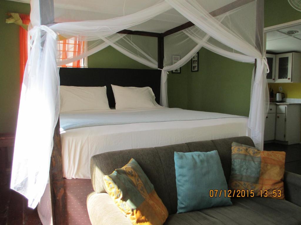 1 dormitorio con 1 cama grande y 1 sofá en Kingsworth Bed and Breakfast, en Kingston