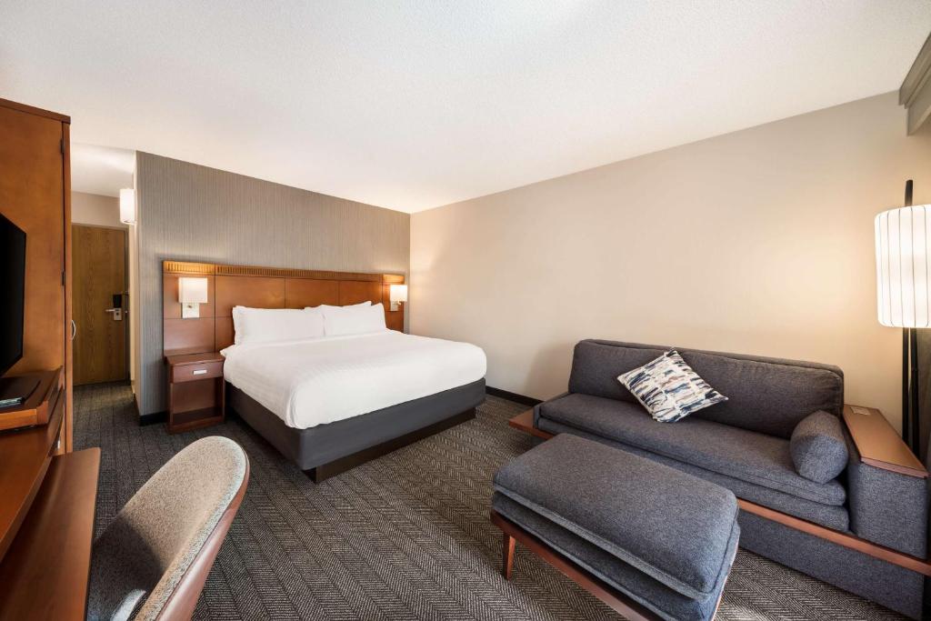 a hotel room with a bed and a couch at Sonesta Select San Jose Airport in San Jose