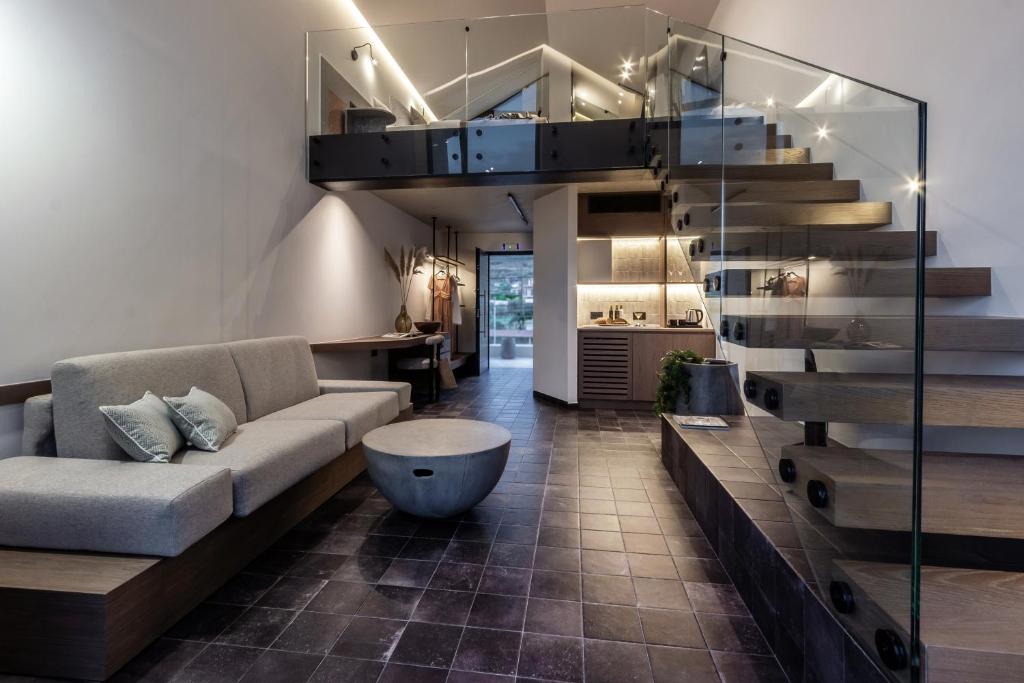 a living room with a couch and a staircase at ACRO Upscale Residences in Kórinthos