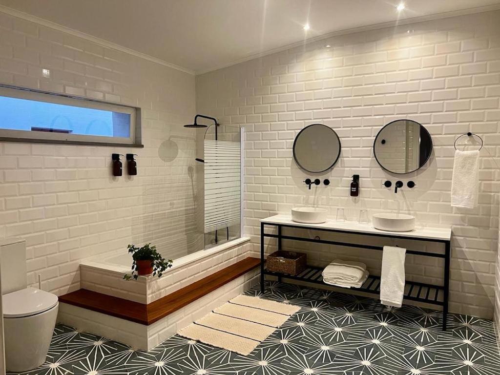 a bathroom with two sinks and a tub and mirror at Viva! Farmhouse in Monsaraz