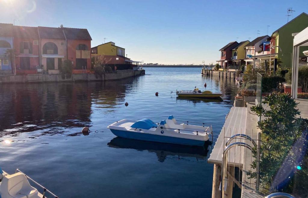 a boat is docked in the water next to houses at Apartment in Albarella 42379 in Palazzo Vianello