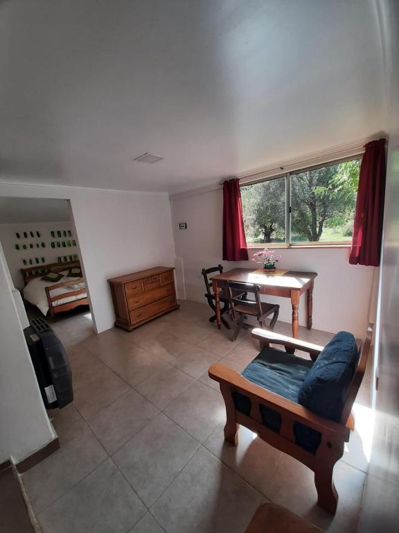 sala de estar con mesa y sofá en casita para dos! en Lago Puelo