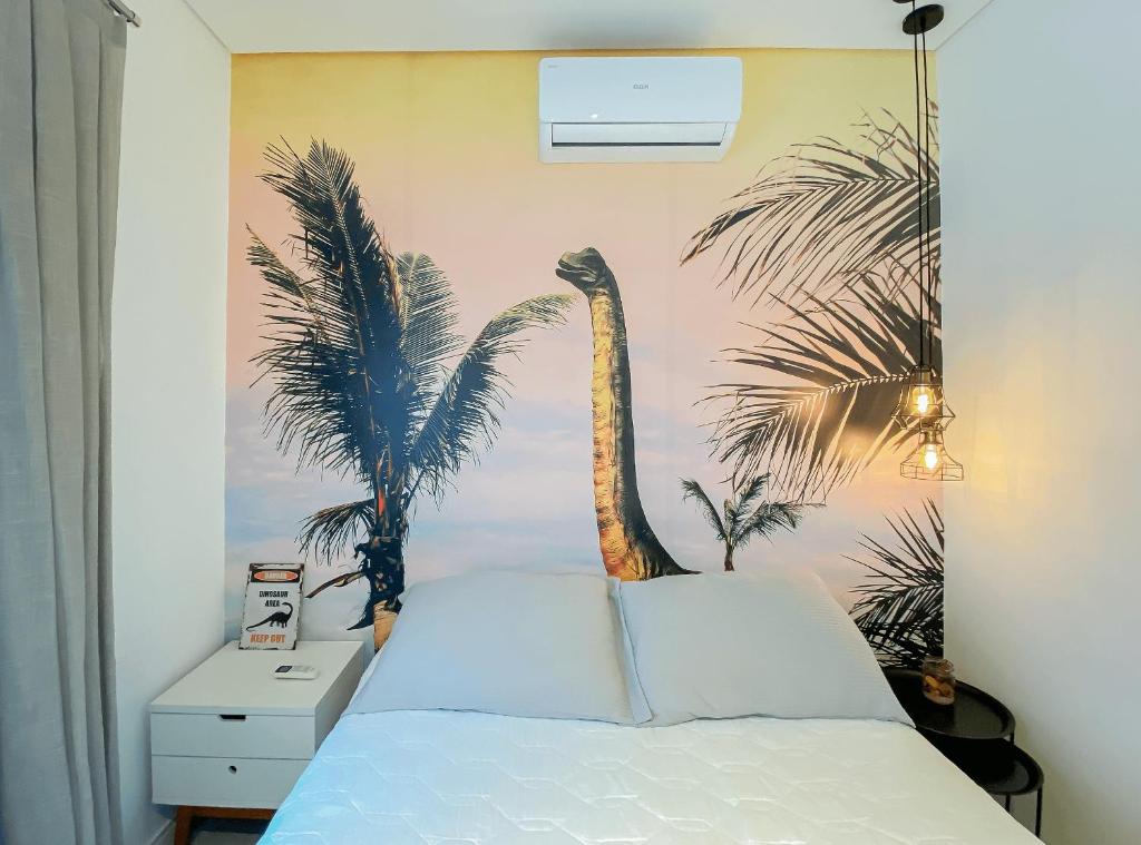 1 dormitorio con 1 cama con un mural de palmeras en Apto temático Dinossauros Pomerode SC, en Pomerode